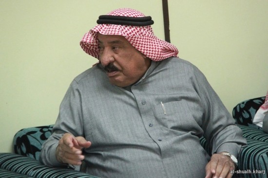 رجل يرتدي زي عربي تقليدي يجلس على أريكة.